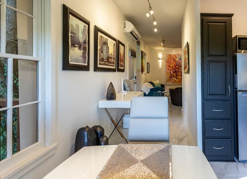 Bright, modern interior featuring art on the walls, a sleek dining table, and an open living space.
